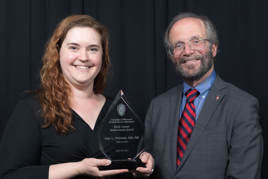 Amy Peterson receiving the Early Career Achievement Award from Dean Robert Golden in 2023