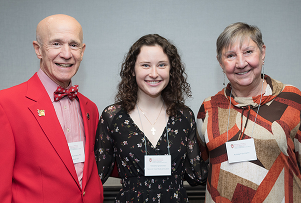 WMAA scholarship recipient smiles with 2 alumni