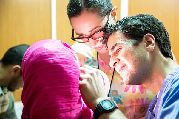 Two doctors looking in a patient's ear
