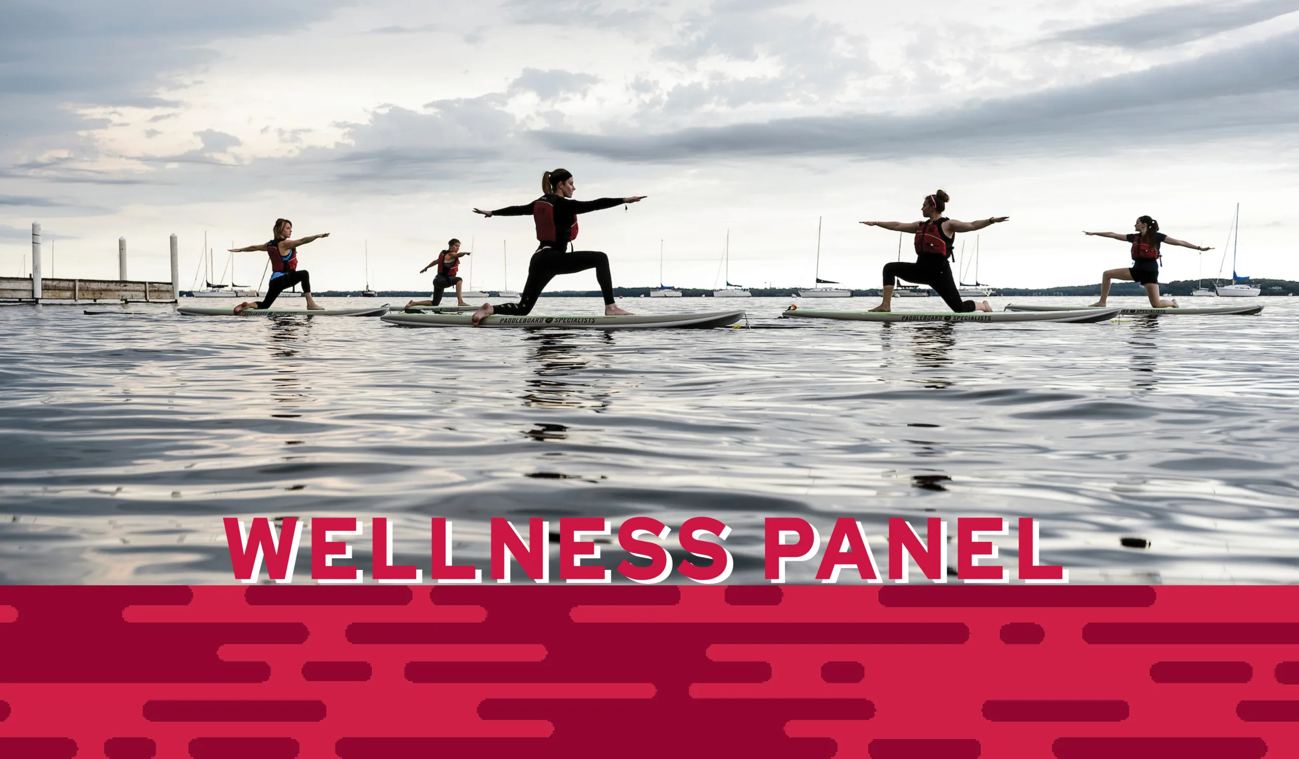 People in yoga poses on paddle boards on a lake