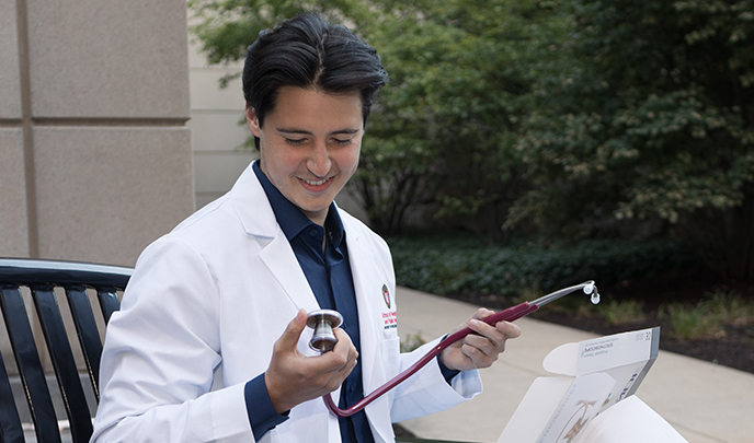 Student unboxing new stethoscope and reading inscription on the bell