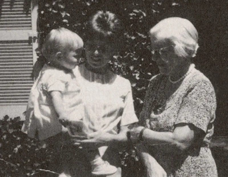 Munro and a child's mother stand together outside a residential home, looking at the small child