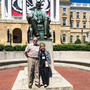 Lee Tyne and Margaret Tyne standing together in front of the Lincoln Statue at Bascom Hall, smiling.