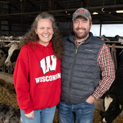 Nicole Knoblock and Sam Zimmerman smiling in a cow barn