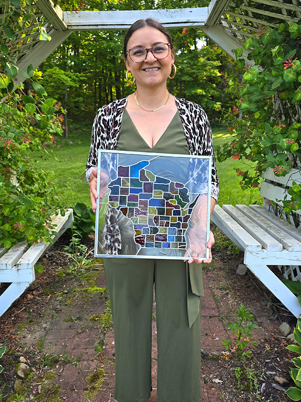 Michelle Clark-Forsting holds the Max Fox Award, a stained glass window depicting the state of Wisconsin