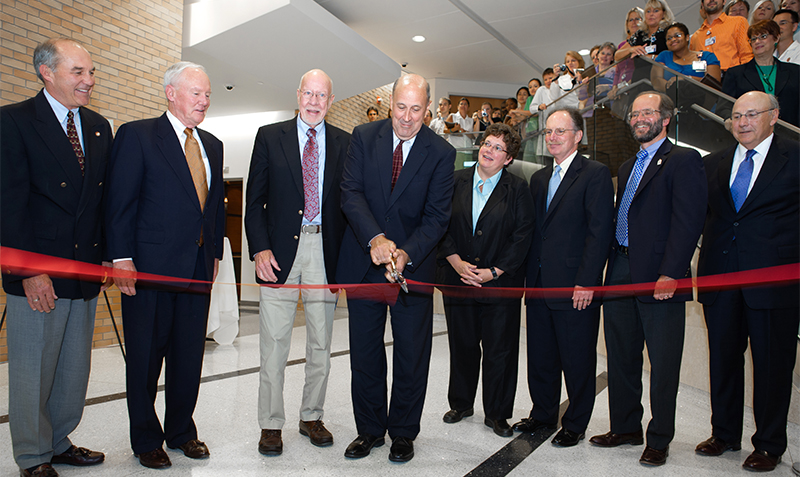 James E. Doyle, Jr. cuts a red ribbon