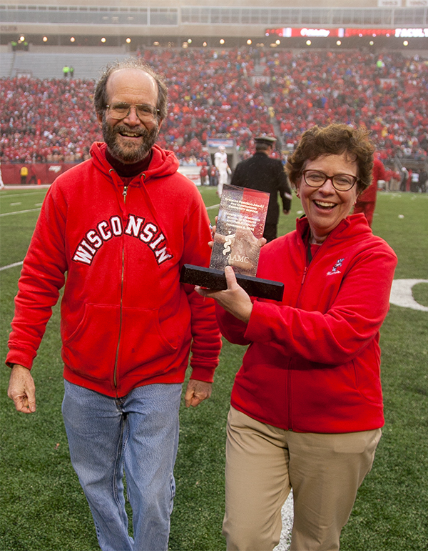 Dean Golden and Rebecca Blank wearing Badger red in Camp Randall Stadium