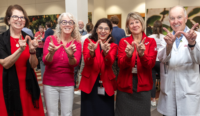 A group of people displaying a W with their hands