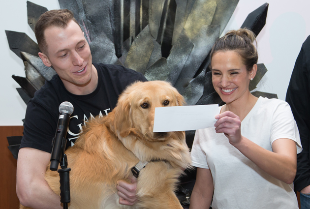 A man, woman and golden retriever dog all look at a piece of paper from the Match Day event in 2018
