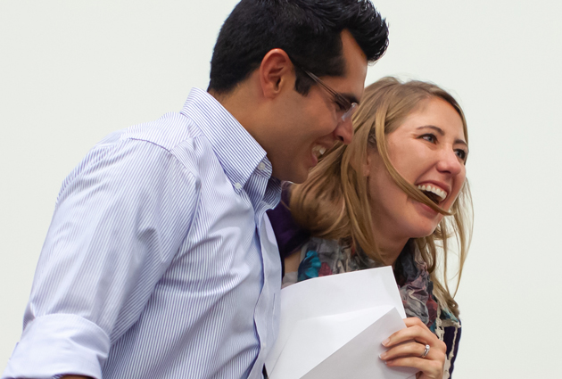 A man and a woman hold a piece of paper at a Match Day event while smiling