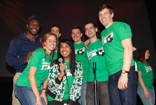 A group of people in green t shirts smile for the camera during a 2017 Match Day event