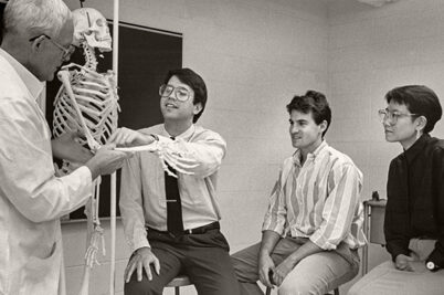 Students learning anatomy using a skeleton