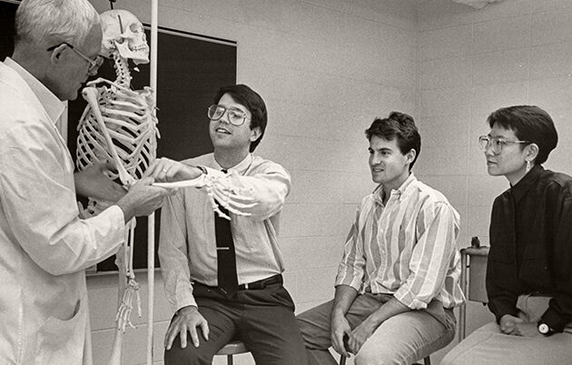 Students learning anatomy using a skeleton