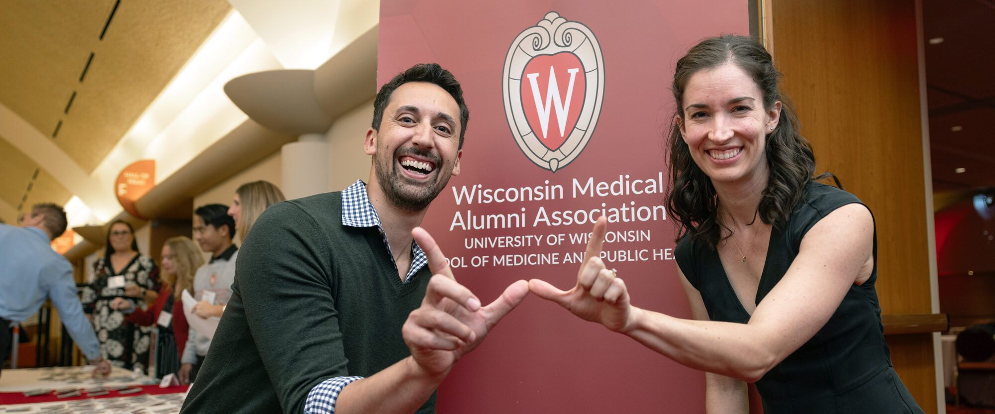 Two people displaying a W with their hands