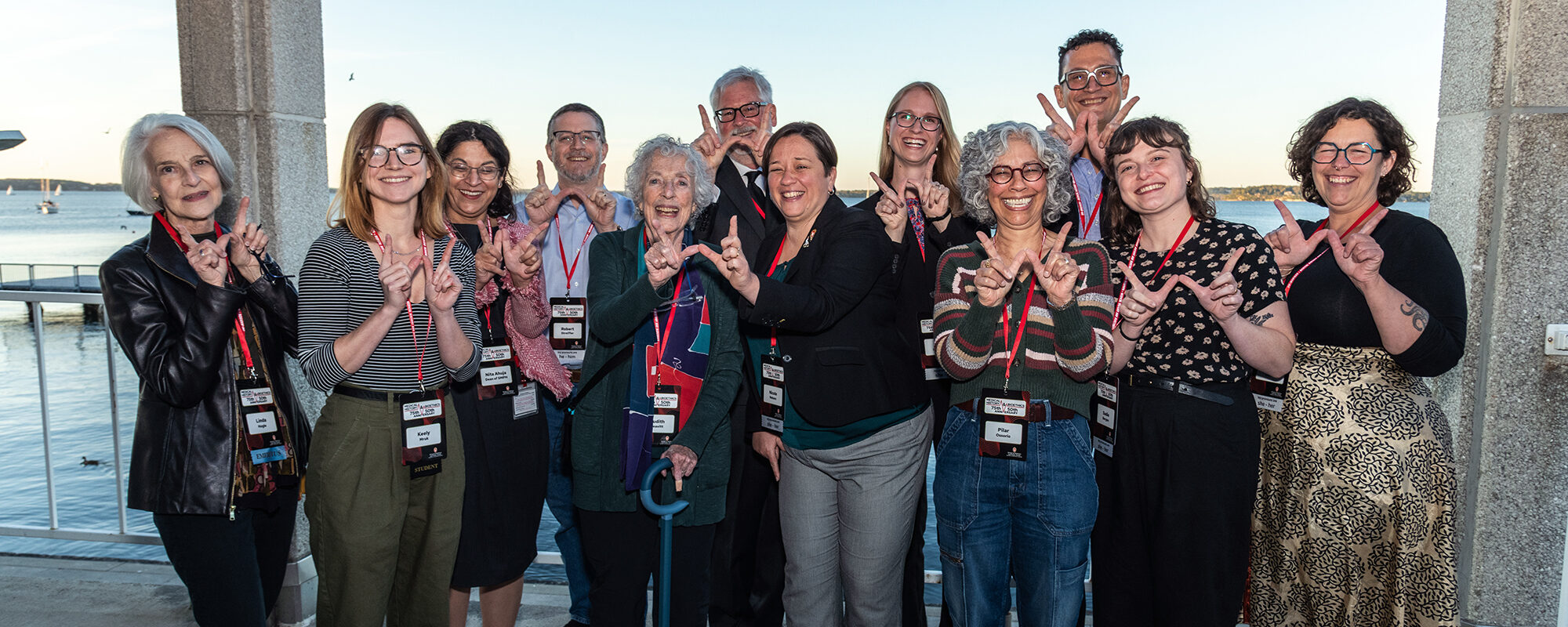 A smiling group making W's with their fingers