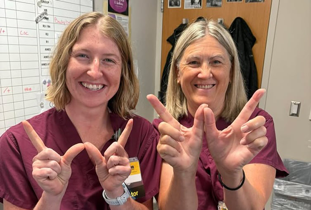 Two women make a "W" with their hands