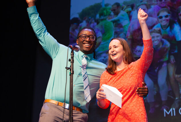 Two people celebrate with their arms in the air at a Match Day event