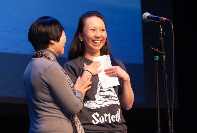 Two people at a Match Day event, one holding an envelope