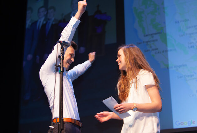 Two people celebrate at a Match Day event, one with his arms in the air