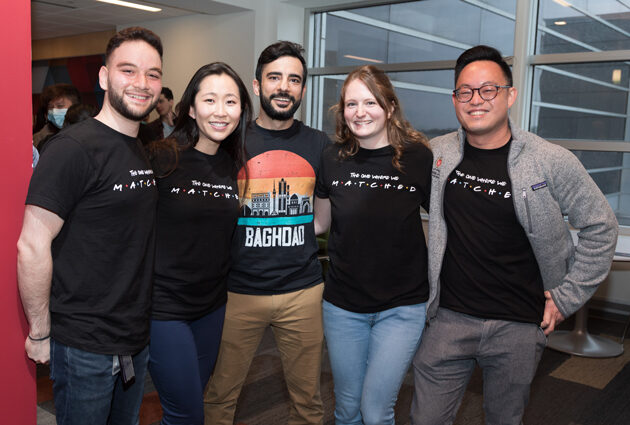 A group of five people smile together during the 2022 Match Day event