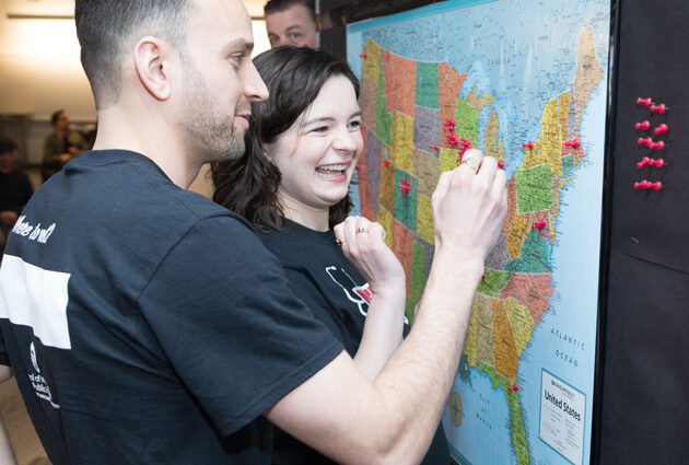 A man and a woman put a pin on a map during the Match Day 2023 event