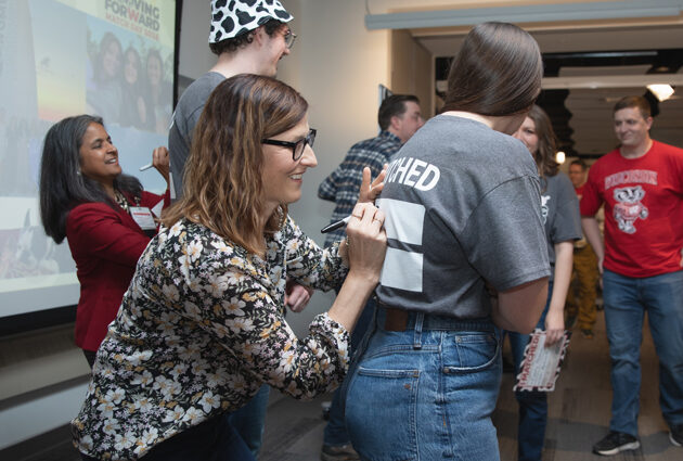 A woman writes on the back of a t shirt during the 2024 Match Day event