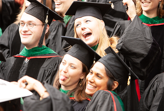Two people shake hands at a graduation ceremony