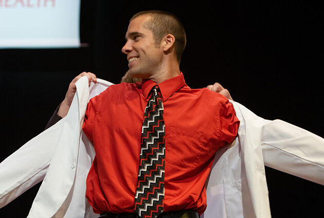 Bob Zemple puts on a white medical coat