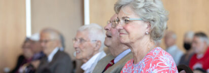 A smiling event attendee sitting in an audience