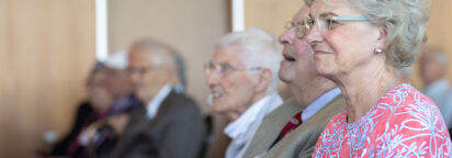 A smiling event attendee sitting in an audience