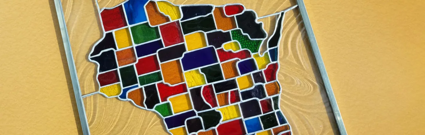 A stained glass pane of Wisconsin with counties in different colors