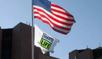 American flag and organ donor flag blowing in the wind