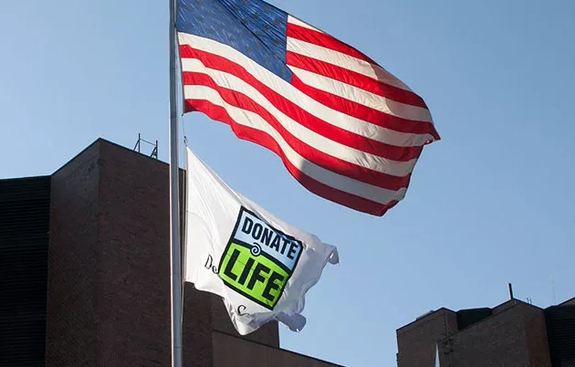 American flag and organ donor flag blowing in the wind