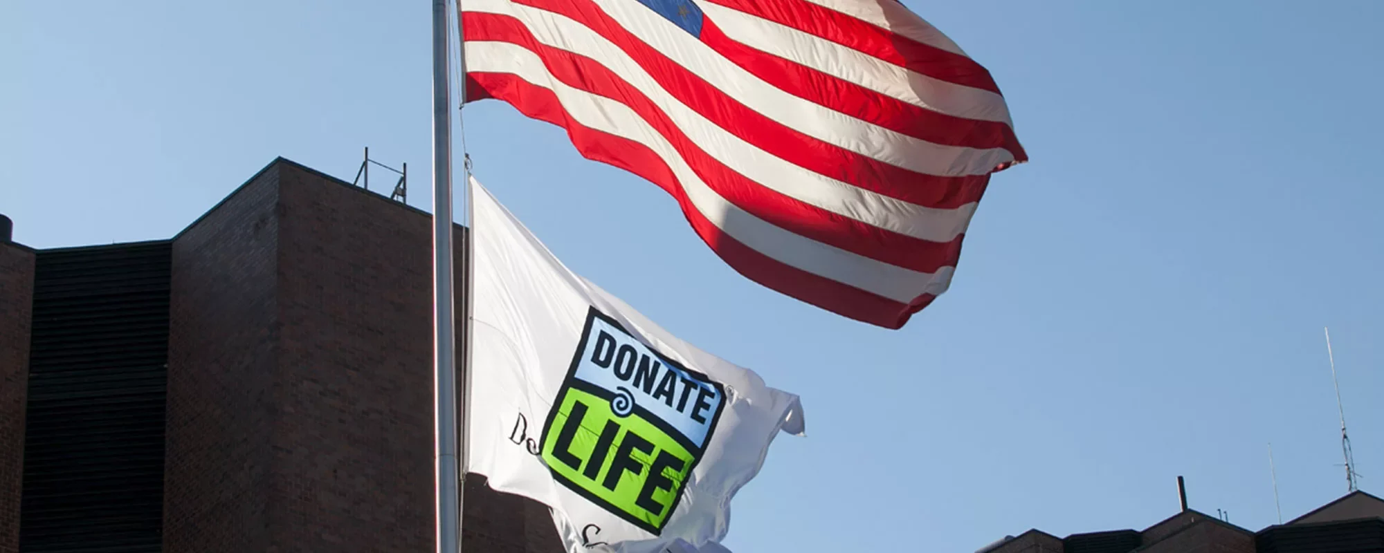 American flag and organ donor flag blowing in the wind