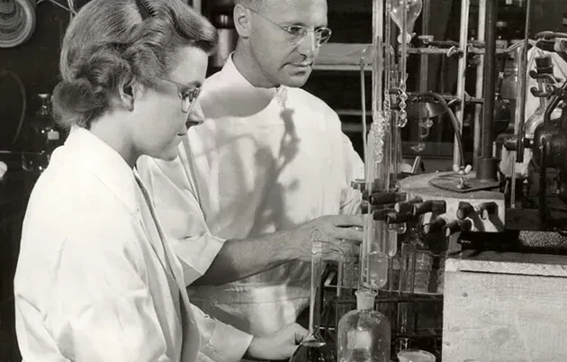 Two scientists working in a lab decades ago