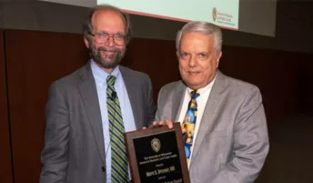 Dean Golden and Marc Drezner posing with a plaque