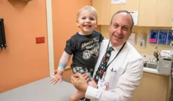 A doctor holding a young patient