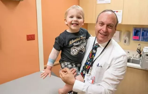 A doctor holding a young patient