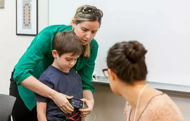 A young boy and his mother talking to a medical student