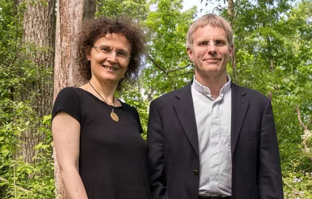 Chiara Cirelli and Giulio Tononi standing in a wooded area