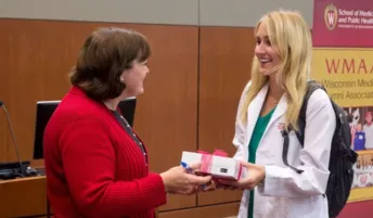 A medical student receives a stethoscope with a smile