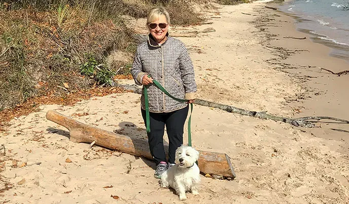 Susan Cowles and her dog on a beach