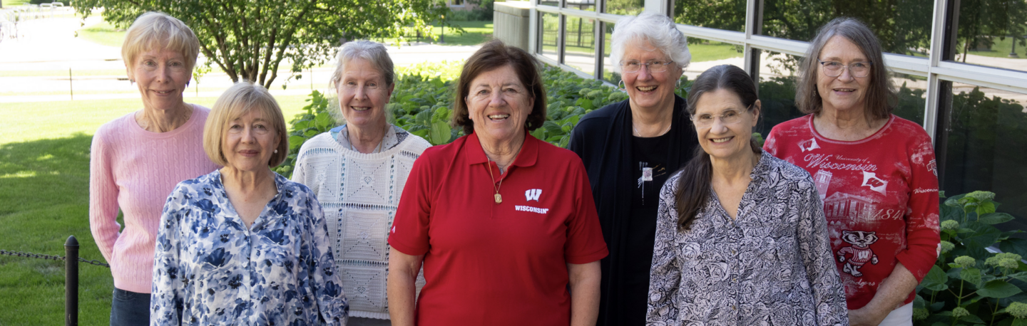 A group of smiling 1974 MD alums pose for a photo outside during Medical Alumni Day