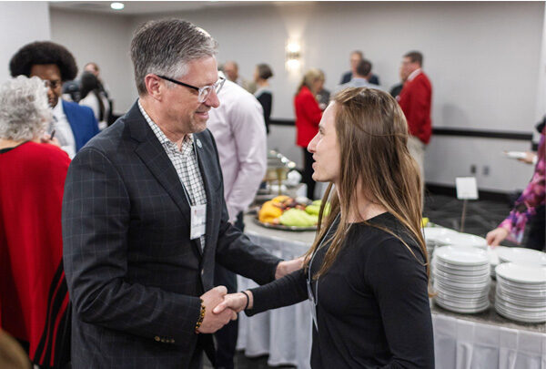 David Hartberg and Amy Frenkel shaking hands at the 2024 Scholarship Reception