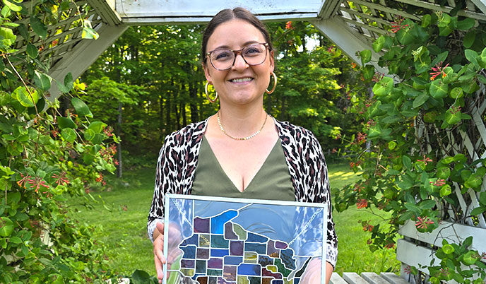 Michelle Clark-Forsting holds the Max Fox Award, a stained glass window depicting the state of Wisconsin