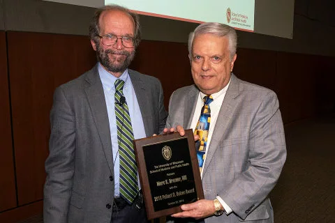 Dean Golden and Marc Drezner posing with a plaque
