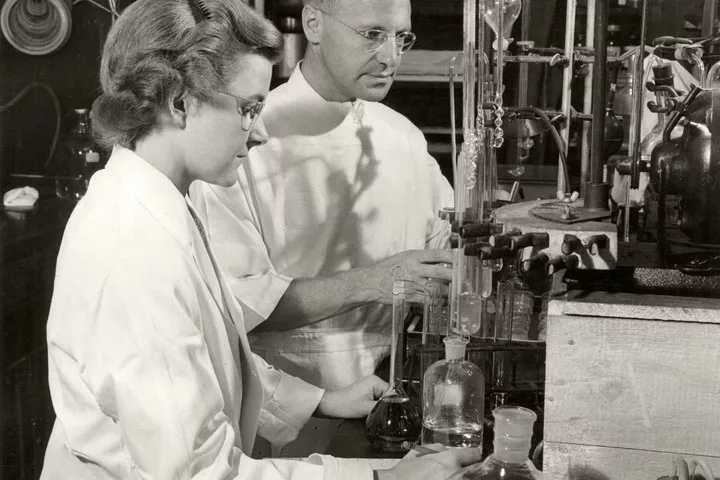 Two scientists conducting research in a lab more than 70 years ago