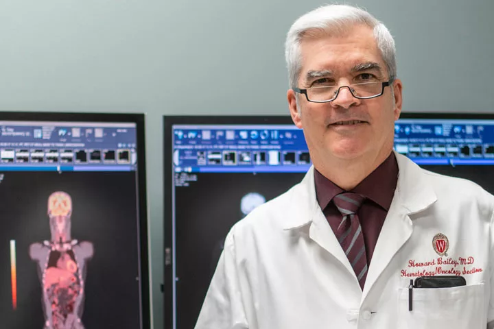 Howard Bailey smiling with computer screens in the background