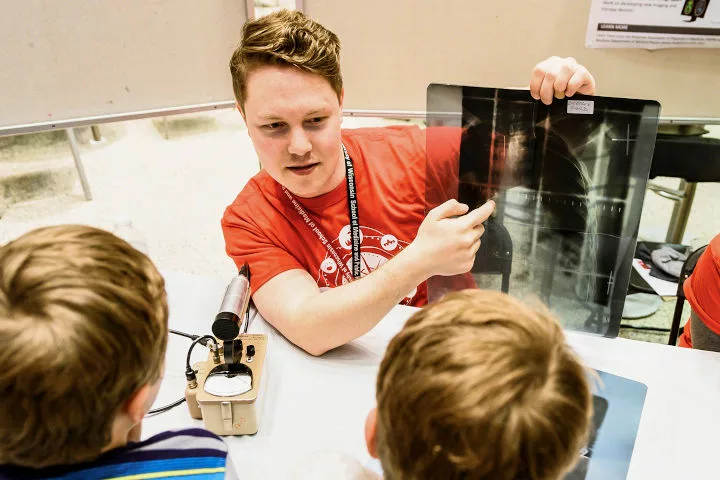 A person shows and describes an x-ray image to young children