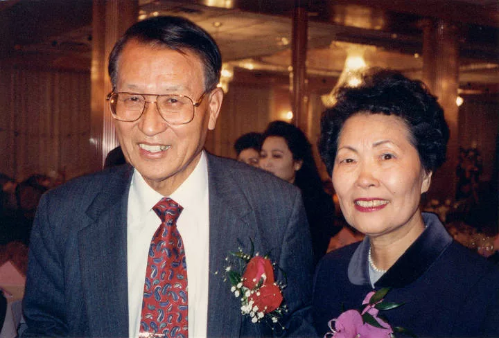 Kiuck and OkSoon Lee smiling at the camera together in formal attire